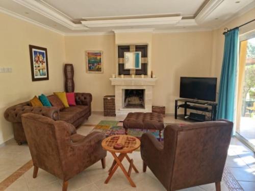 a living room with a couch and a fireplace at Ozankoy Villa in Kyrenia