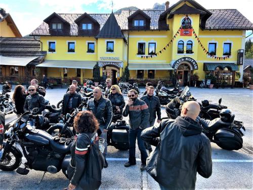 een groep mensen die voor motorfietsen staan bij Hotel Kotnik Superior in Kranjska Gora