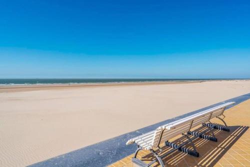 a bench sitting on the beach near the ocean at Raversea op enkele minuten wandelen van de zee. in Ostend