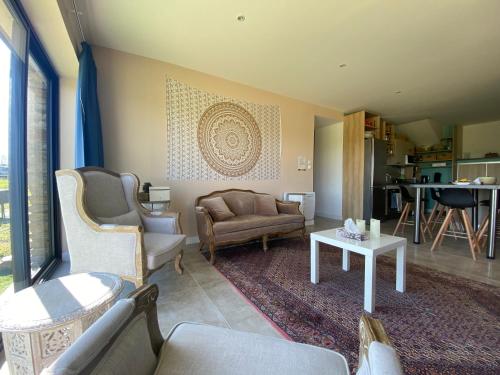 un salon avec un canapé et une table dans l'établissement Villa- Calme - Campagne - Bien être, à Saint-Grégoire