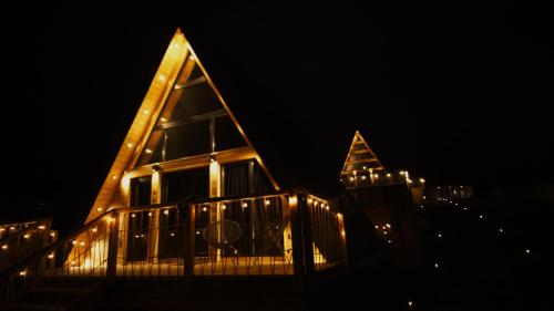 a house lit up at night with lights at Cabanele A Frame, Salciua Noua in Sălciua Nouă