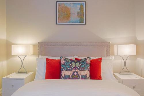 a bedroom with a white bed with two lamps at Stylish Grade II Listed Apartment: The London in Cheltenham