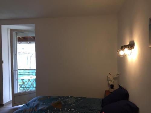 a bedroom with a bed and a door to a balcony at L'esprit libre2 in Lacaune