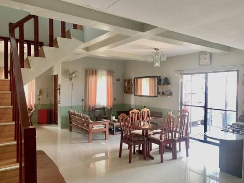 uma sala de jantar e sala de estar com mesa e cadeiras em Cozy House with Peaceful Vibes em Dinalupihan