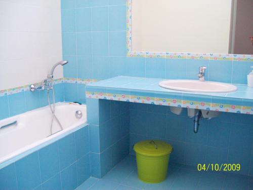 a blue tiled bathroom with a sink and a bath tub at Seaside Villa Hoopoe just steps from the beach in Schinias