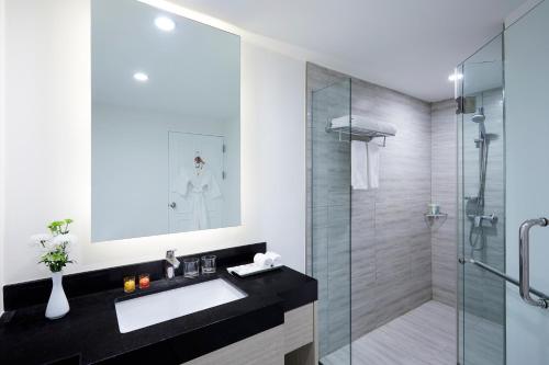 a bathroom with a sink and a shower at Somerset Park Suanplu Bangkok in Bangkok