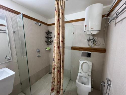 een badkamer met een douche, een toilet en een wastafel bij Little Heaven in Nainital