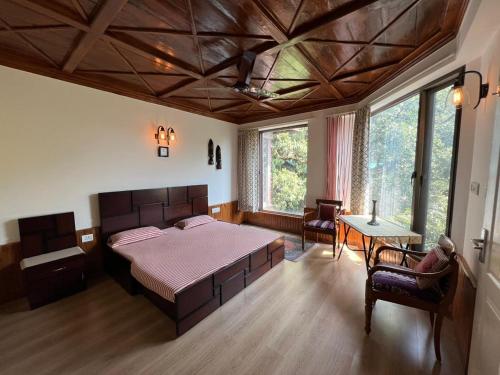 een slaapkamer met een groot bed en een tafel bij Little Heaven in Nainital