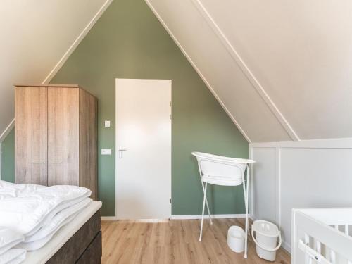 Un dormitorio abuhardillado con una cama y una silla. en Holiday Home in Scherpenisse near the Sea, en Scherpenisse