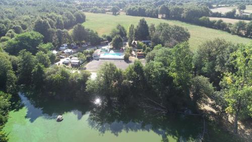 - une vue aérienne sur une maison et un lac dans l'établissement Camping La Venise Du Bocage, à Nesmy