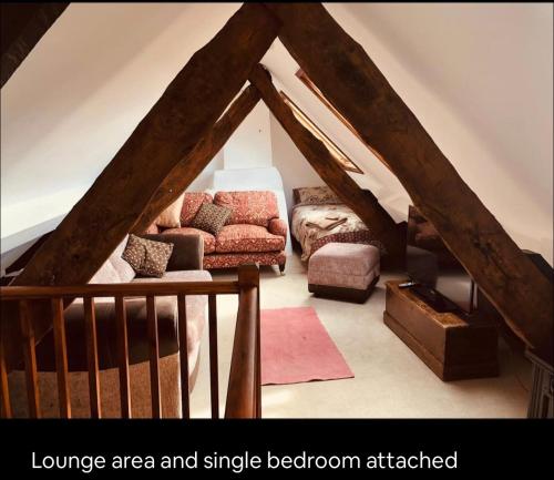 a attic living room with a couch and a television at Sleepy Hollow in Taunton