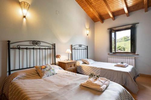 een slaapkamer met 2 bedden en een raam bij Apartamento Rural Celada 2 