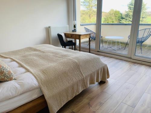 - une chambre avec un lit, une table et un balcon dans l'établissement Ferienhaus Sonnenaufgang, à Nohfelden