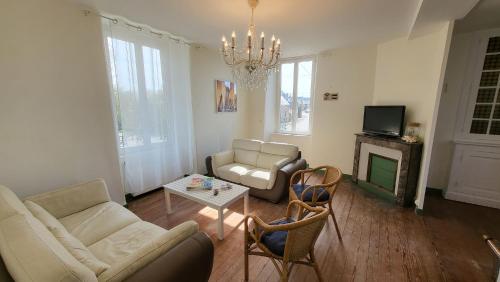 a living room with a couch and a table at Gite de la Fontaine in La Bazouge-des-Alleux