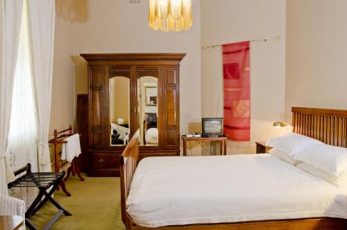 1 dormitorio con cama y espejo grande en Imperial Fine Accommodation, en Broken Hill