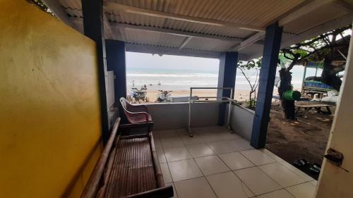 a balcony with a bench and a view of the beach at Villa Family Pantai Citepus Pelabuhanratu in Citepus