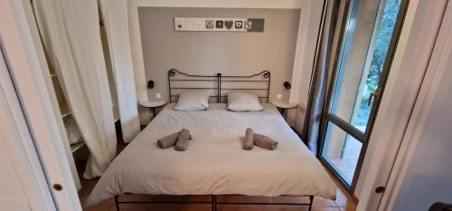 een slaapkamer met een bed met twee schoenen erop bij Appartement sur golf de L'Isle-Sur-La-Sorgue in Saumane-de-Vaucluse