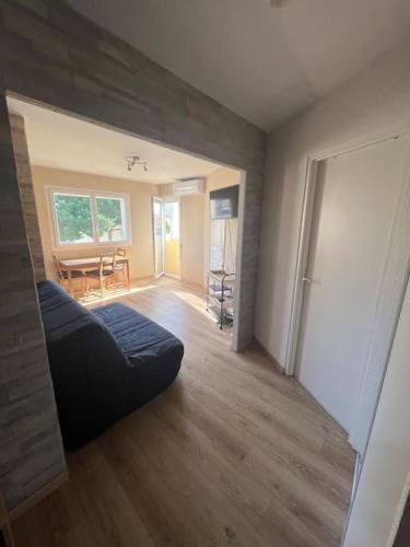 - un salon avec un canapé au milieu d'une pièce dans l'établissement Charmant studio cabin avec piscine., au Cap d'Agde