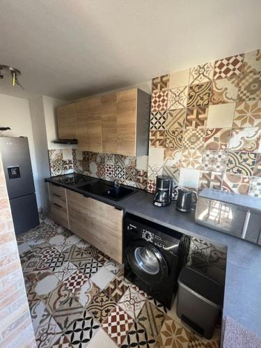 une cuisine avec un lave-linge et un sèche-linge sur un mur dans l'établissement Charmant studio cabin avec piscine., au Cap d'Agde