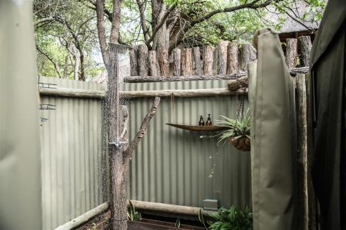 a privacy fence with a tree in front of it at NDZUTI BUSH CAMP in Balule Game Reserve