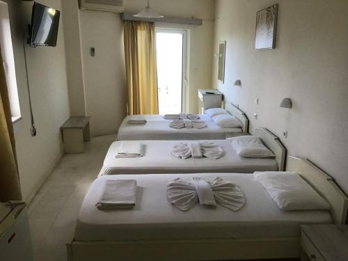 a group of four beds in a room at Regina Hotel in Kissamos