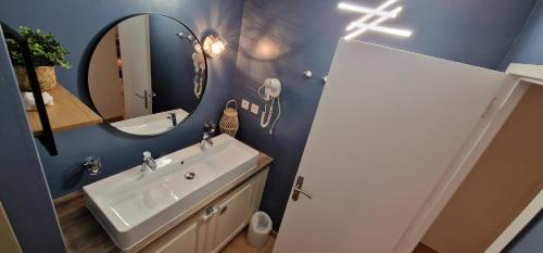 a bathroom with a sink and a mirror at Appartement sur golf de L'Isle-Sur-La-Sorgue in Saumane-de-Vaucluse
