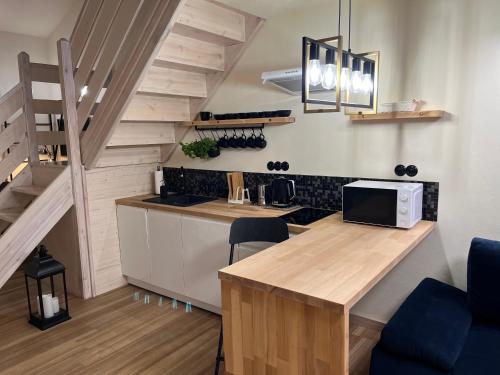 uma cozinha com um balcão de madeira e escadas em Pensjonat Dom Latarnika em Grzybowo
