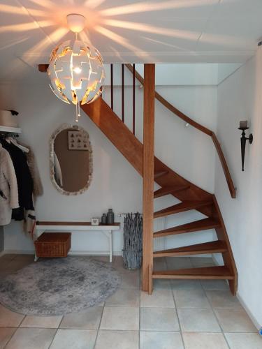 a hallway with a staircase and a chandelier at Beach Villa Makkum met sauna in Makkum