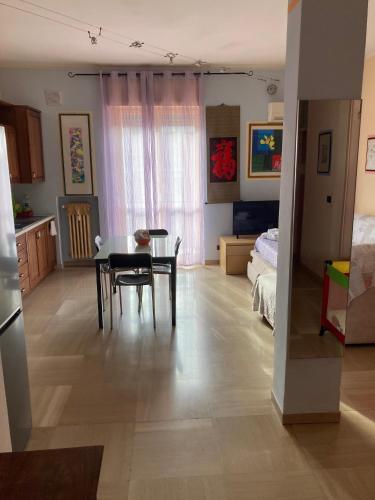 DOLOMITI 5.3 في فيرونا: مطبخ وغرفة معيشة مع طاولة وكراسي