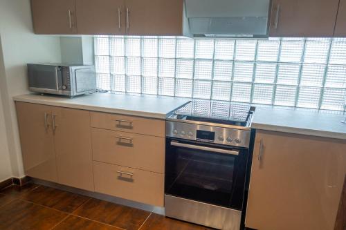 a kitchen with a stove and a microwave at Armonia Studios Preveza in Preveza
