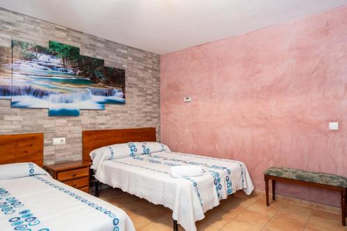 a room with two beds and a painting on the wall at 2 hermanas in Es Pujols