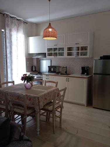 een keuken met een tafel met stoelen en een koelkast bij Ariadni's apartment 6 Heraklion Thenon in Heraklion