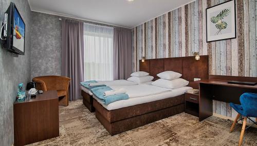Pokój hotelowy z łóżkiem i biurkiem w obiekcie Hotel Biancas w mieście Kosakowo