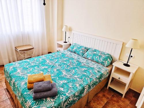 Dormitorio pequeño con cama con colcha azul en Benimar 1, en Cala de Finestrat