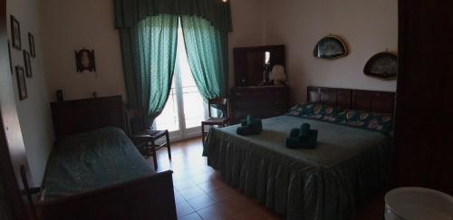 ein Schlafzimmer mit einem Bett, einem Sofa und einem Fenster in der Unterkunft Villetta indipendente immersa nella natura delle Langhe . in Cortemilia