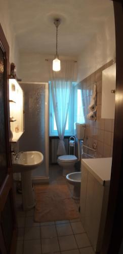 ein Bad mit einem Waschbecken, einem WC und einem Fenster in der Unterkunft Villetta indipendente immersa nella natura delle Langhe . in Cortemilia