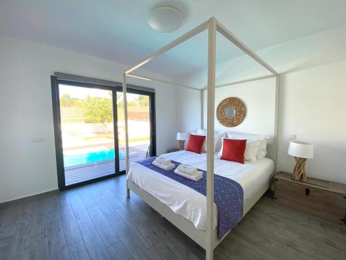 una camera con letto a baldacchino e piscina all'aperto di Cairnvillas Villa Flow C40 Luxury Villa with Private Swimming Pool near Beach ad Aljezur