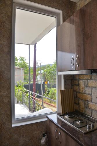 a window in a kitchen with a view of a balcony at Surami Guest House - სახლი სურამში in Surami