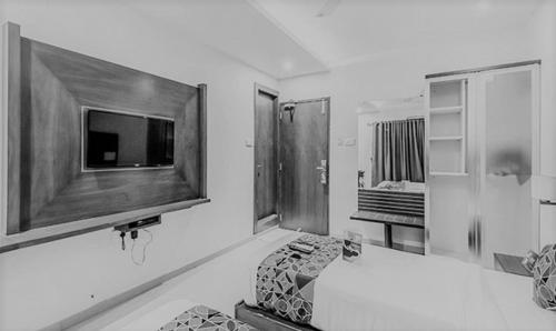 een woonkamer met een flatscreen-tv aan de muur bij FabHotel Realm Inn in Mumbai