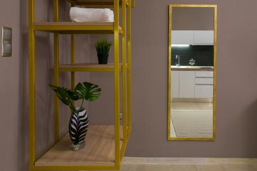 a yellow shelf with a vase in front of a mirror at Marizas luxury suites #1 in Thessaloniki