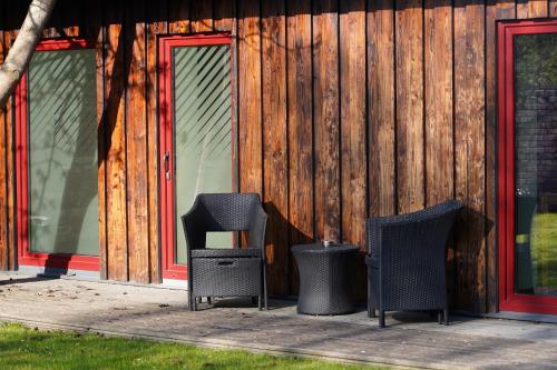 three chairs and trash cans in front of a building at Altribute Studio w Sauna Secure Parking wifi 90mbs in Liepāja