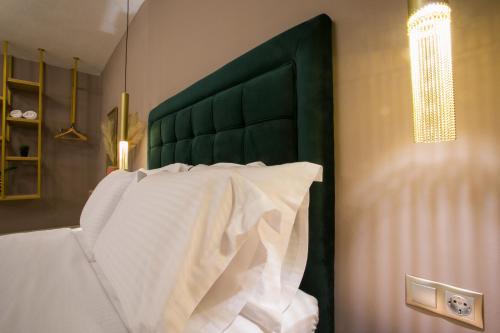 a bed with a green headboard in a bedroom at Marizas luxury suites #1 in Thessaloniki