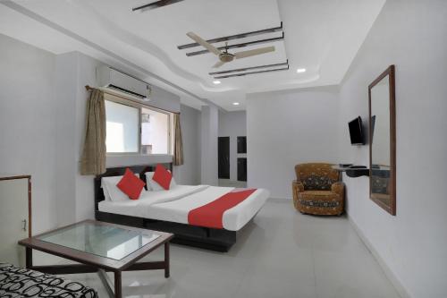 アーメダバードにあるFlagship Hotel Rudra Palaceのベッドとテーブルが備わるホテルルームです。