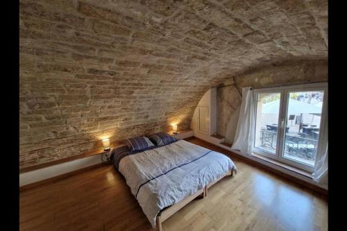 une chambre avec un lit et un mur de briques dans l'établissement Superbe Appartement Rénové - Centre Historique, à Montpellier