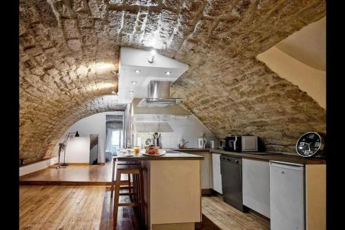 une cuisine avec un mur en pierre et un comptoir dans l'établissement Superbe Appartement Rénové - Centre Historique, à Montpellier
