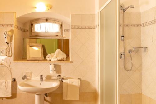 a bathroom with a sink and a shower at Hotel Minerva in Assisi