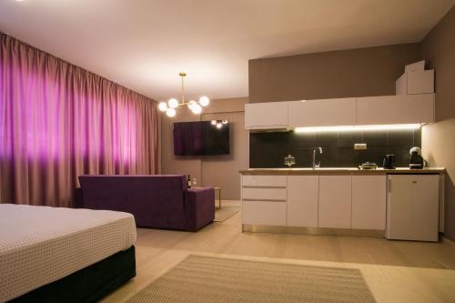 een slaapkamer met een bed en een keuken met paarse gordijnen bij Marizas luxury suites #1 in Thessaloniki