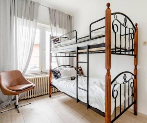 a bedroom with two bunk beds and a chair at Family townhouse 3 bedrooms in Brussels