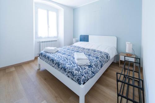 a bedroom with a bed with a blue and white bedspread at 105 - La Casa di Jacopo, fronte e vista mare in centro a Riva Trigoso, 20 metri dalla spiaggia in Sestri Levante