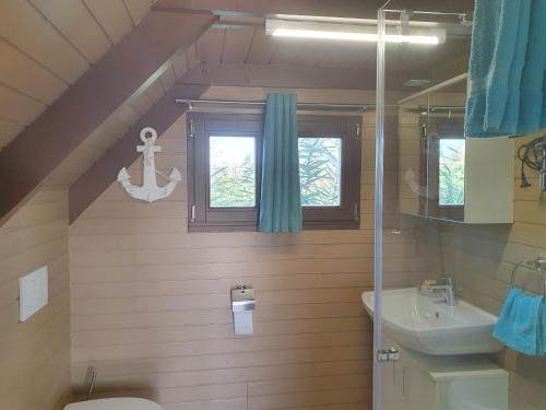 a bathroom with a sink toilet and a window at Chalet im See- Nr 44 in Rust